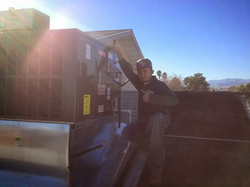 HVAC technician performing Heat Pump Repair on a rooftop unit in Beloit